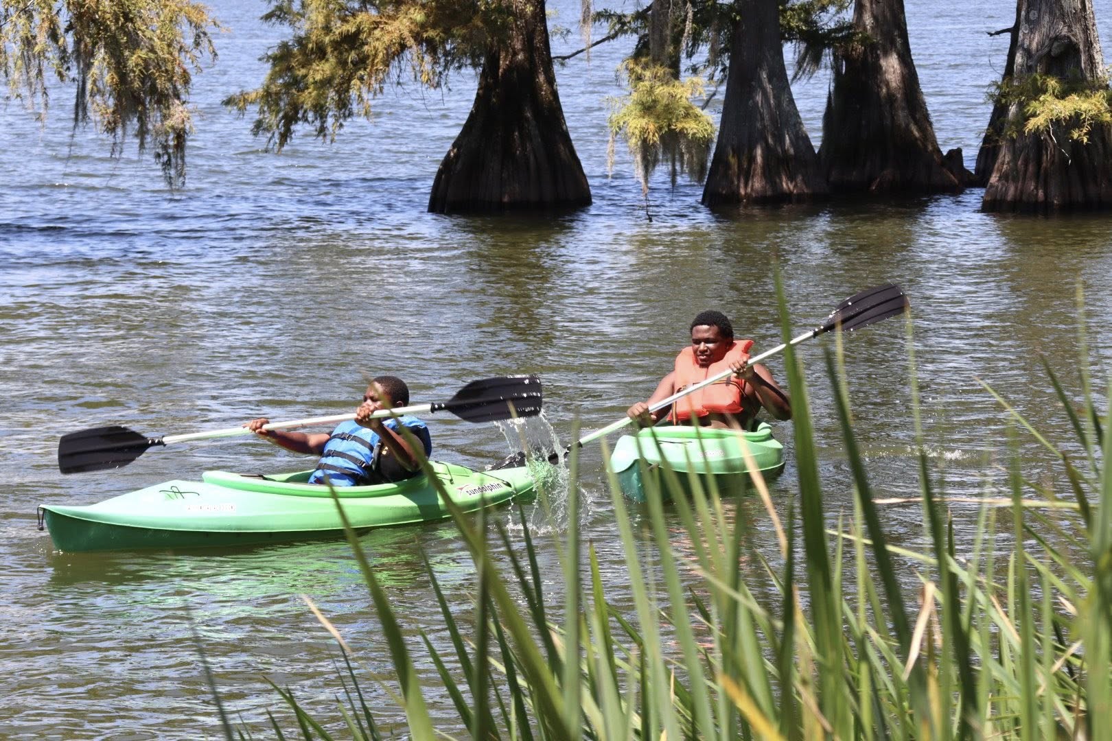Two boys kayaking in a lake.